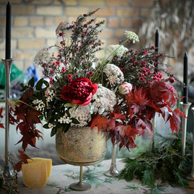 Bunch of various fresh flowers placed near candles and prepared for decorating banquet table