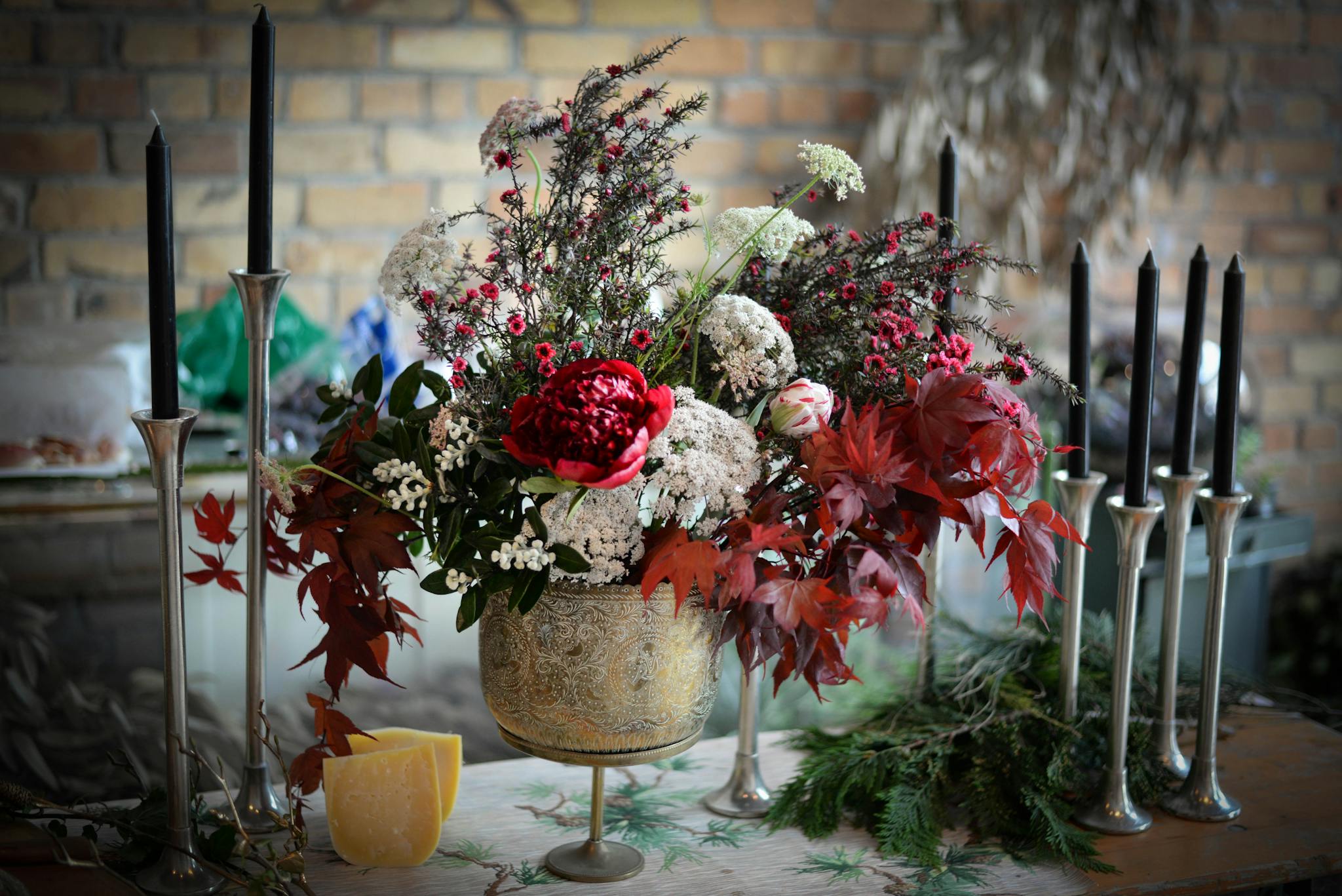 Bunch of various fresh flowers placed near candles and prepared for decorating banquet table