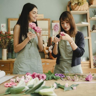 Diverse female coworkers preparing roses for floral decoration