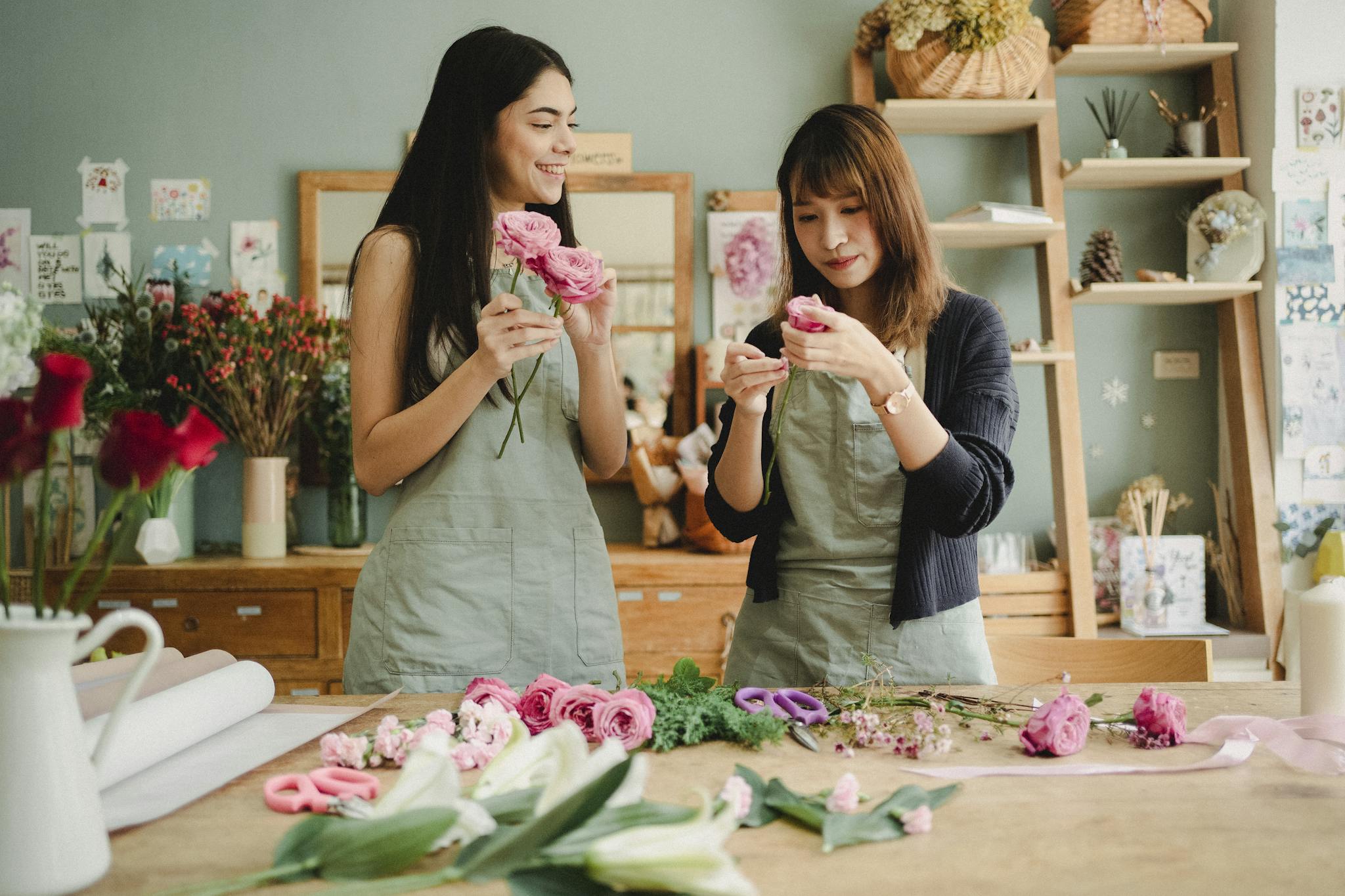 Diverse female coworkers preparing roses for floral decoration