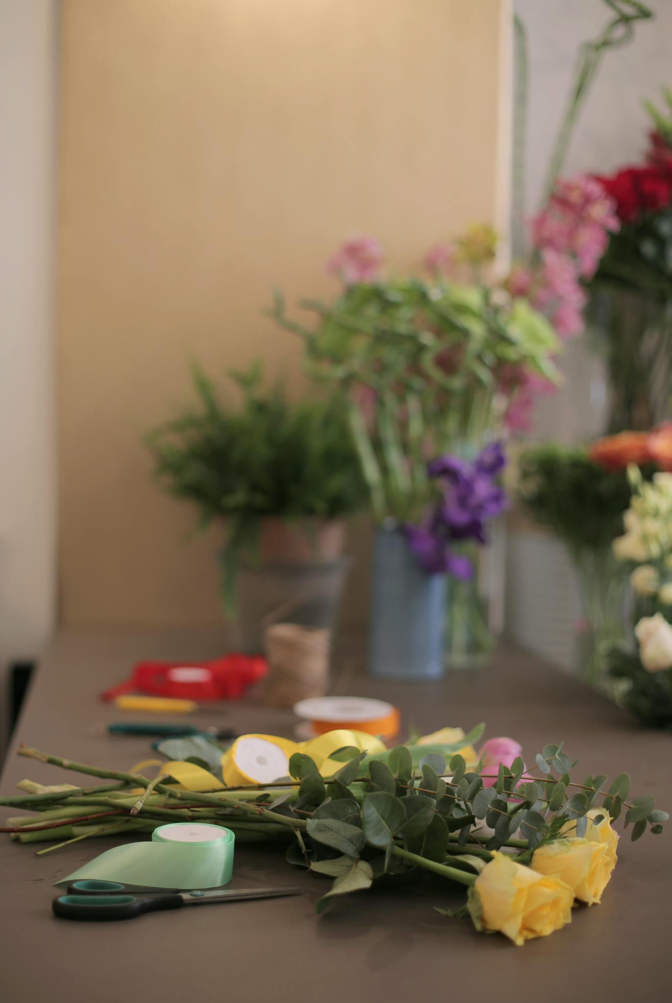 Side view of uncompleted bouquet with yellow roses on counter in flower shop